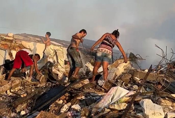 Moradores buscam alimentos em supermercado demolido após incêndio na PB